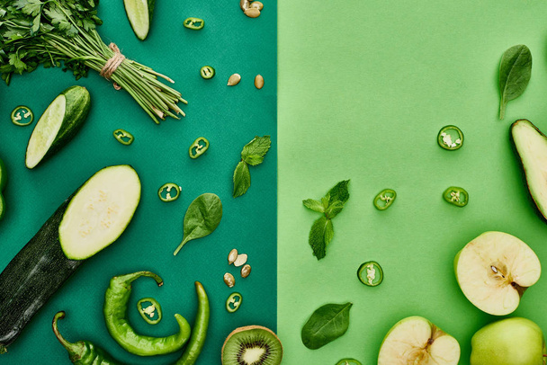 top view of apples, avocado, cucumbers, peppers, kiwi, greenery, pumpkin seeds and zucchini - 写真・画像