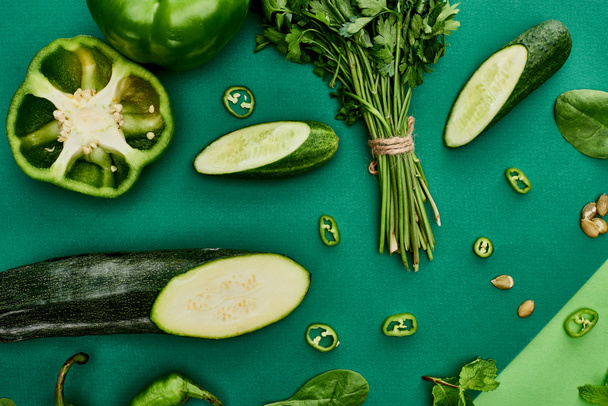 top view of cucumbers, peppers, pumpkin seeds, greenery and zucchini - Фото, изображение