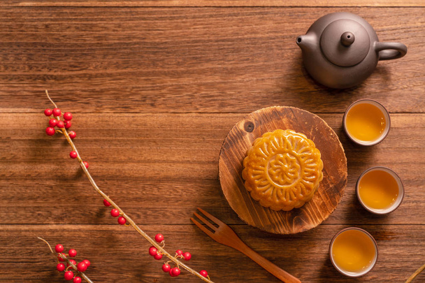 Chinese traditional pastry Moon cake Mooncake with tea cups on bamboo serving tray on wooden background for Mid-Autumn Festival, top view, flat lay. - Fotó, kép