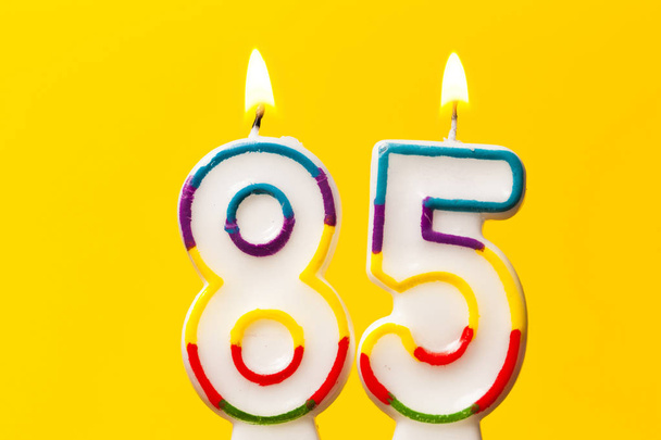 Number 85 birthday celebration candle against a bright yellow ba - Zdjęcie, obraz