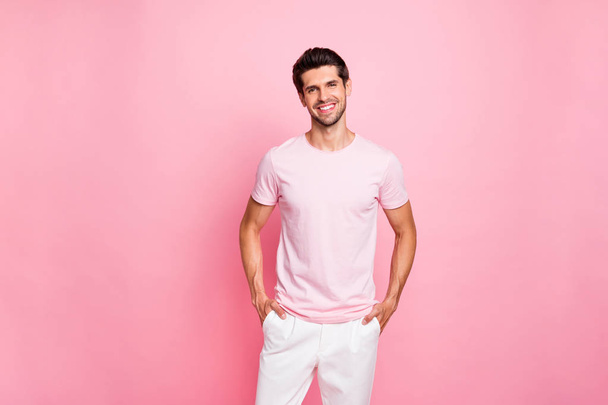 Portrait of his he nice attractive lovely content cheerful cheery glad successful guy holding hands in pockets isolated over pink pastel background - Valokuva, kuva