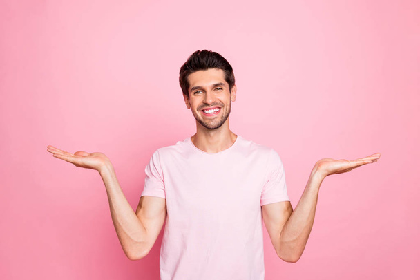 Portrait of his he nice attractive lovely cheerful cheery confident content guy holding copy space promotion good surprise gift present ad advert isolated over pink pastel background - Foto, Imagen