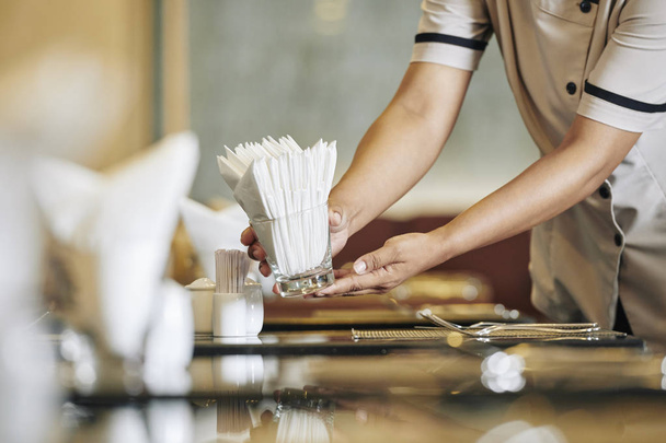 Close-up of waitress setting the table in the restaurant she putting the napkins on the table - Photo, Image