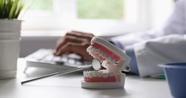 tandarts werken in tandheelkundige klinieken Office typen op computer toetsenbord focus op tand model - Video