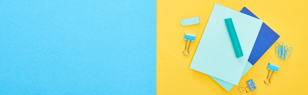 Panoramic shot of different blue stationery with sheets of paper on bicolor background - Photo, image