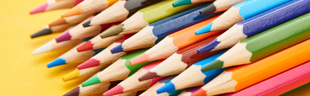 Sharpened ends of color pencils on yellow background - Fotografie, Obrázek
