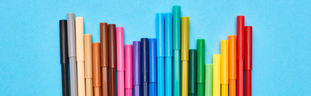 Vue panoramique d'un ensemble de stylos feutre de couleur vive isolés sur du bleu
 - Photo, image