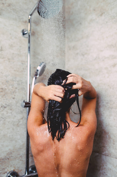 Hermosa mujer tomando ducha en su baño
. - Foto, imagen