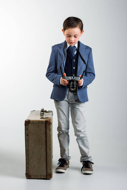 Jeune garçon habillé avec appareil photo et valise
 - Photo, image