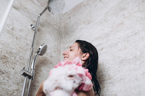 Hermosa mujer tomando ducha en su baño
. - Foto, imagen