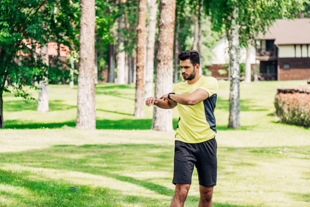 joven deportista guapo haciendo ejercicio en el parque verde
  - Foto, Imagen