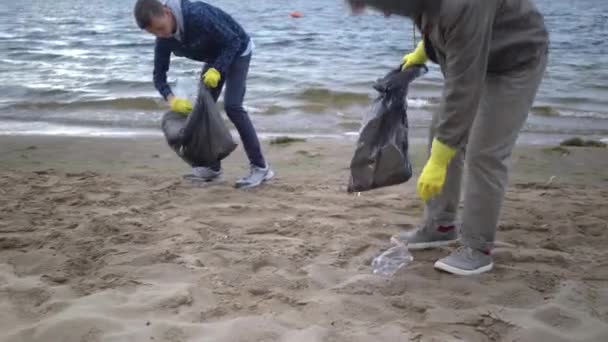 vrijwilligers heffen vuilnis op in het strand - Video