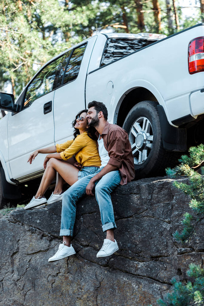 heureux barbu homme et attrayant fille assis près de la voiture dans les bois
  - Photo, image