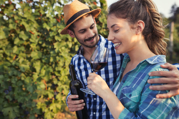 Couple in love working at winemaker vineyard and tasting wines - Foto, imagen