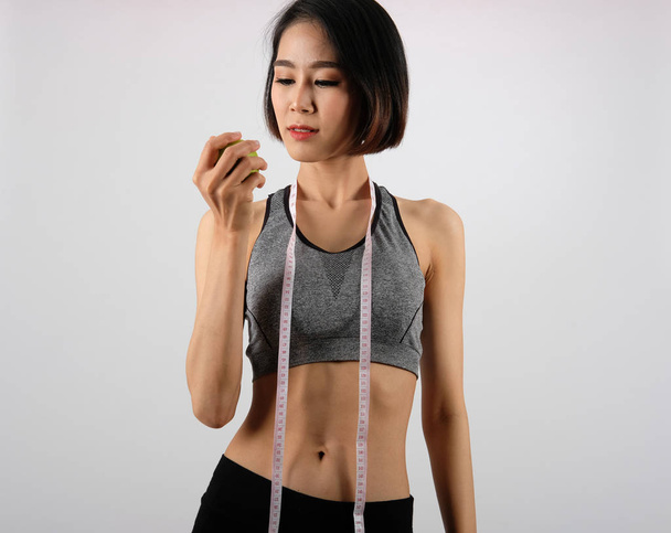 sporty fitness woman in sportswear with apple.  healthy sport li - Foto, afbeelding