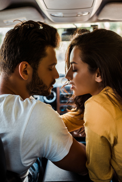 side view of handsome man and attractive woman with closed eyes in car  - Foto, Bild
