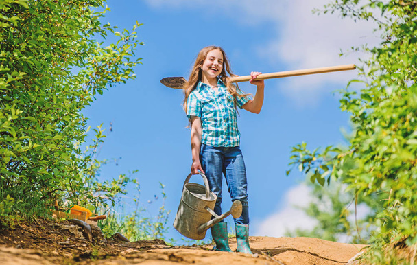 Gardening. kid worker sunny outdoor. family bonding. spring country side village. future success. little girl on rancho. summer farming. farmer little girl. garden tools, shovel and watering can - Фото, зображення