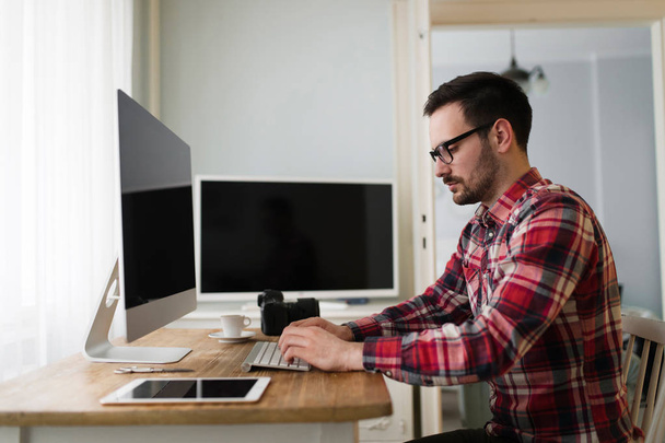 Portrait of young attractive man doing design work on computer - Photo, Image