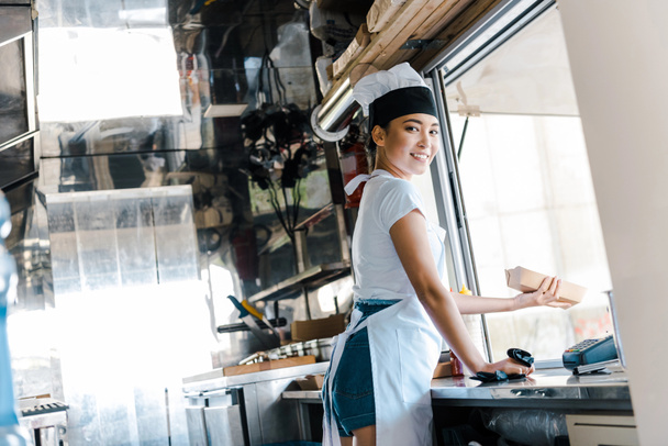 happy asian woman holding carton plate in food truck  - 写真・画像