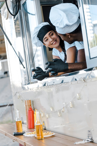 alegre asiático menina olhando para africano americano homem no comida caminhão
  - Foto, Imagem