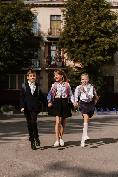 Schoolchildren have fun in the schoolyard.Children hurry to school.back to school - Photo, Image