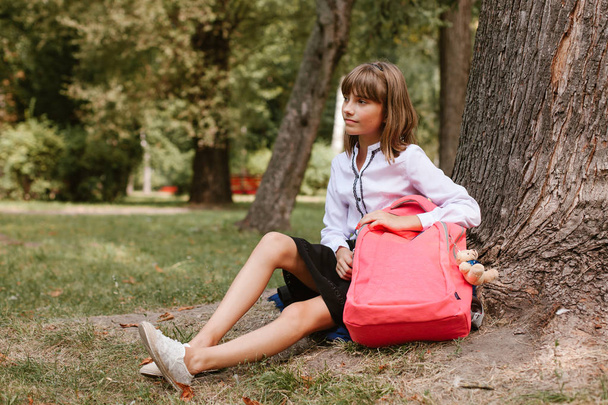 女子高生は公園の木の下に座っている - 写真・画像