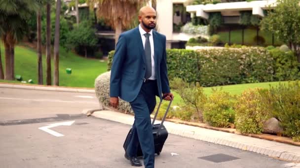 Homme d'affaires indien portant un costume bleu marchant avec un sac de voyage ou une valise
 - Séquence, vidéo