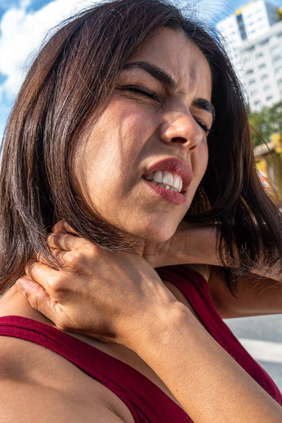 Страждаюча жінка масажує її жорстку шию
 - Фото, зображення