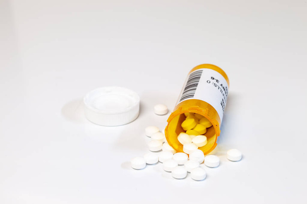 白い背景に分離された一般的な錠剤や錠剤を持つ処方ボトル. - 写真・画像