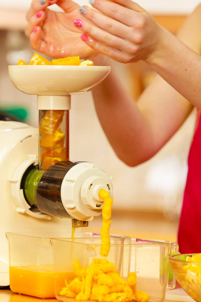 Woman making orange juice in juicer machine - Fotografie, Obrázek