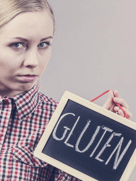 Woman holding board with gluten sign - 写真・画像