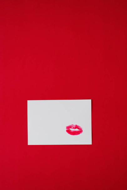 szminka oznacza pocałunki na białym papierze na czerwonym tle. miejsce kopiowania - Zdjęcie, obraz
