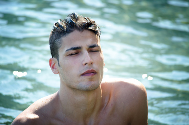 Handsome young man coming out of water - Foto, imagen
