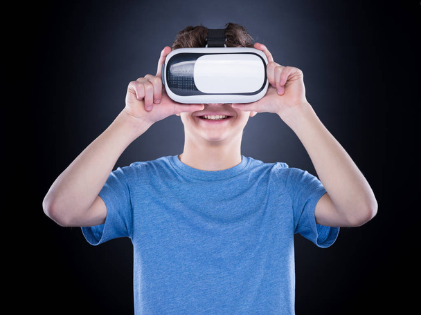 Teen boy in VR glasses - Фото, изображение