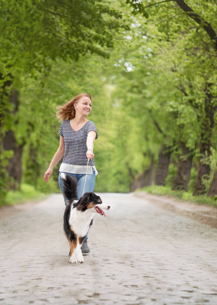 Happy woman with dog on road - Foto, imagen