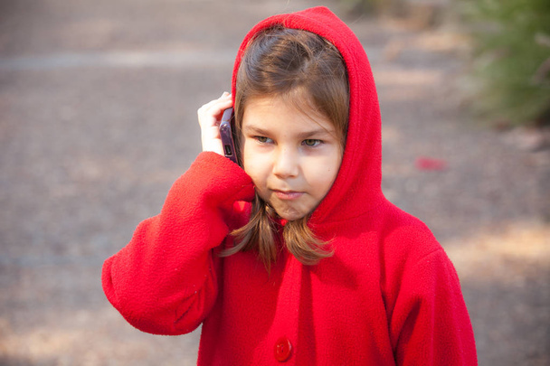 Дівчина в червоному з мобільним в парку
 - Фото, зображення