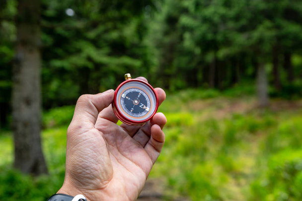 Compass in the hands in the Carpathian forest. Traveling in the  - Φωτογραφία, εικόνα