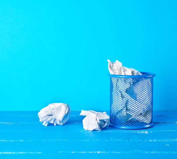 μπλε μεταλλικός κουβάς γεμάτος με τσαλακωμένο λευκό χαρτί - Φωτογραφία, εικόνα