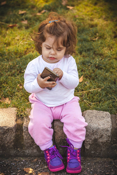 bambino con cellulare nel parco - Foto, immagini