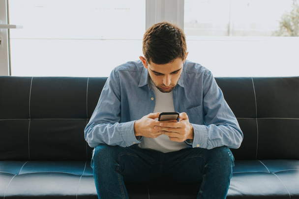 young man or teenager with mobile phone indoors - Foto, immagini