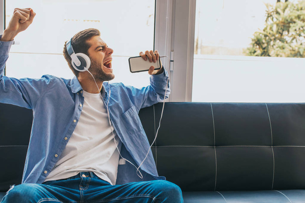 young singing with phone and headphones - Photo, image