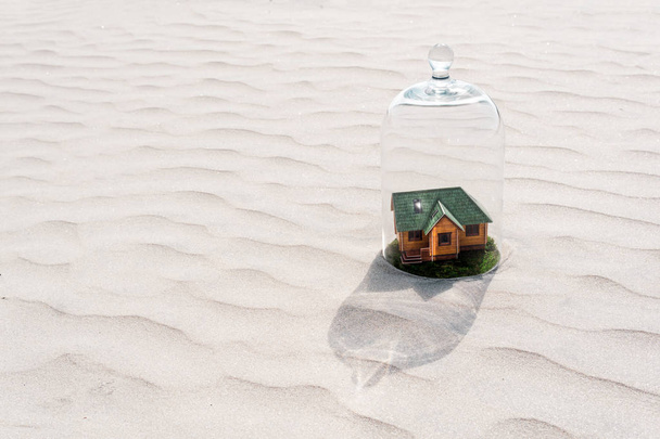 砂漠のガラスドームの下に芝生を持つおもちゃの家 - 写真・画像