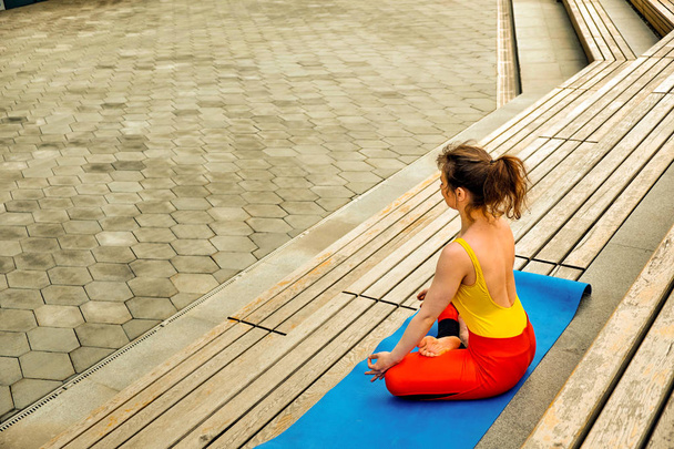Portrait of beautiful young woman doing yoga in the street. - Foto, imagen