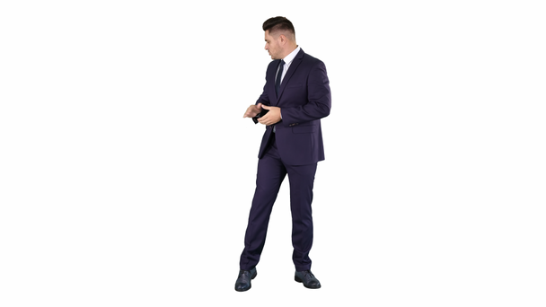 Smiling businessman pointing on something and talknig on white background. - Footage, Video