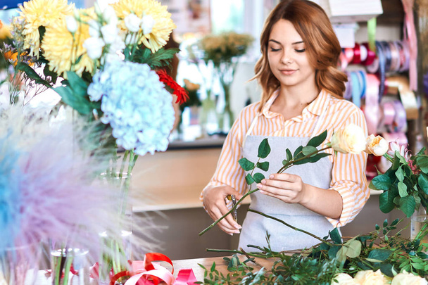 woman preparing roses for celebrating special event. duties of florists - Foto, imagen