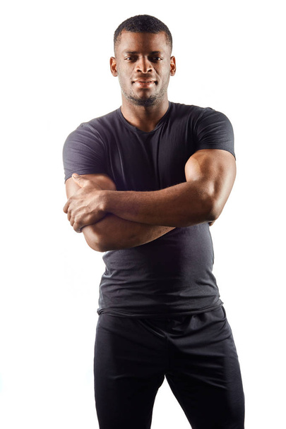 sexy, krutý, svalnatý muž v černém tričku, stojící se zkříženýma rukama - Fotografie, Obrázek