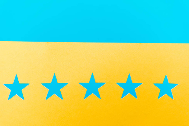 top view of blue stars on yellow and blue background  - Zdjęcie, obraz