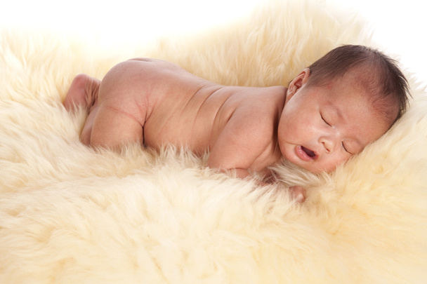 Oriental baby laying on a fur rug - Fotoğraf, Görsel