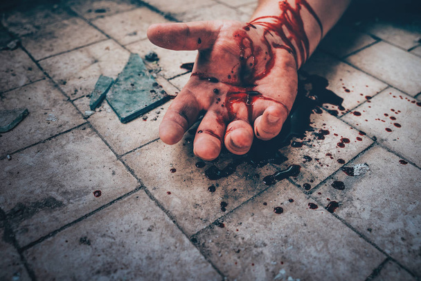 Escena del crimen con mano humana en sangre en el suelo del hombre asesinado por asesinato, parte del cuerpo muerto de cerca
. - Foto, Imagen