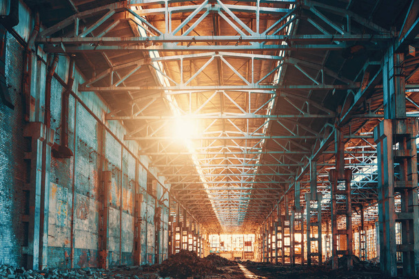 Zrujnowany i opuszczony magazyn fabryki przemysłowej hangar w świetle zachodu słońca, - Zdjęcie, obraz